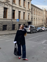 A woman wears jumpsuit and a coat